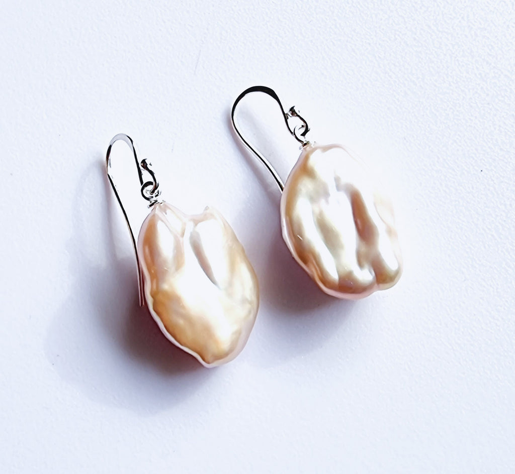 A beautiful pair of natural pink freshwater baroque pearls designed on sterling silver hooks. Simple yet elegant.