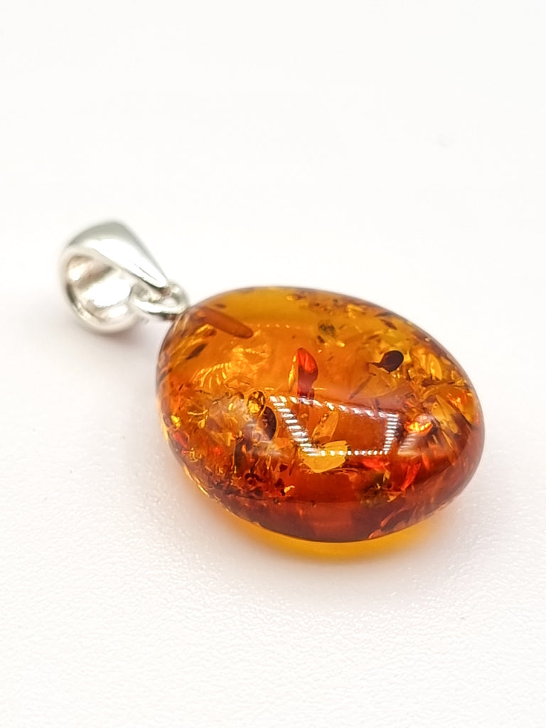 A medium sized gorgeous teardrop shaped natural Baltic Amber pendant in a vibrant cognac hue, crafted with a tiny 925 sterling silver bail. With no bezel, the tone of Amber adds a luxurious charm. Origin Poland.