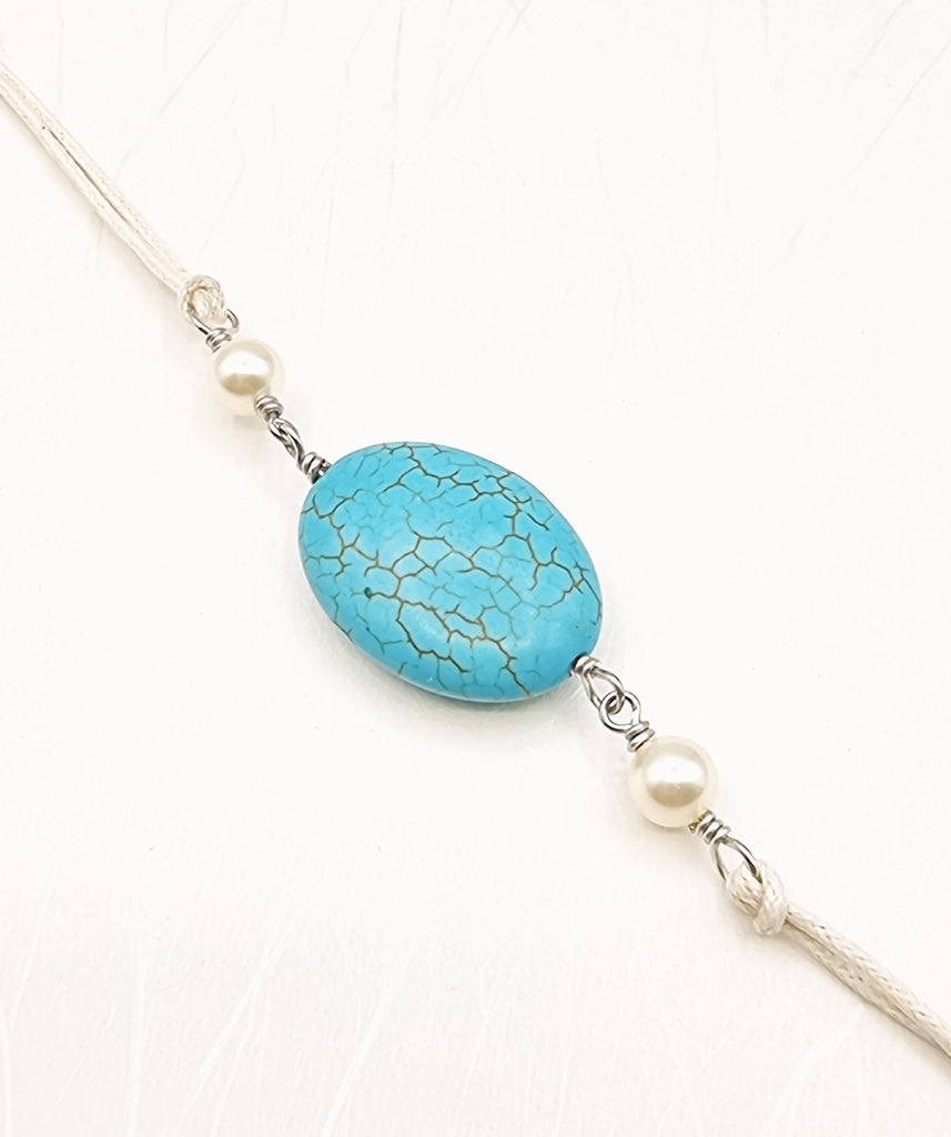 A handmade Rakhi delicately crafted with a beautiful natural Howlite gemstone, reminiscent of Turquoise and lustrous imitation pearls. Truly unique and one-of-a-kind!
