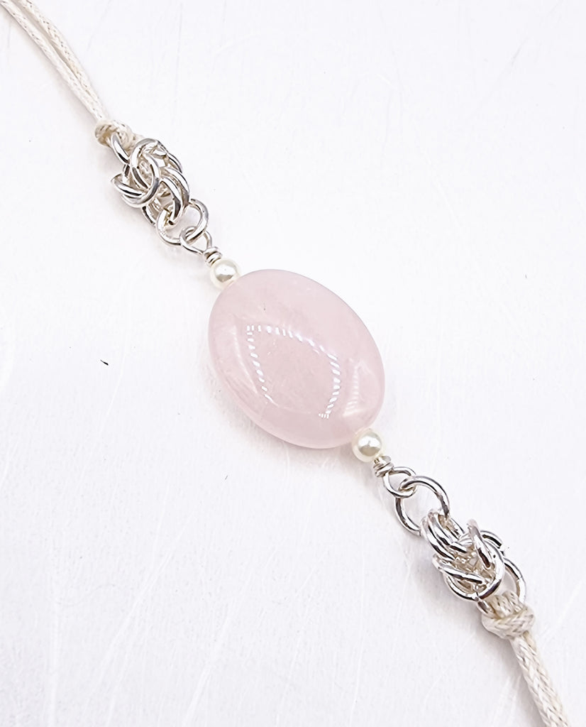 A handmade Rakhi delicately crafted with a beautiful natural Rose Quartz gemstone and tiny white freshwater pearls, with stylish Byzantine accent, symbolising love and harmony. Truly unique and one-of-a-kind!