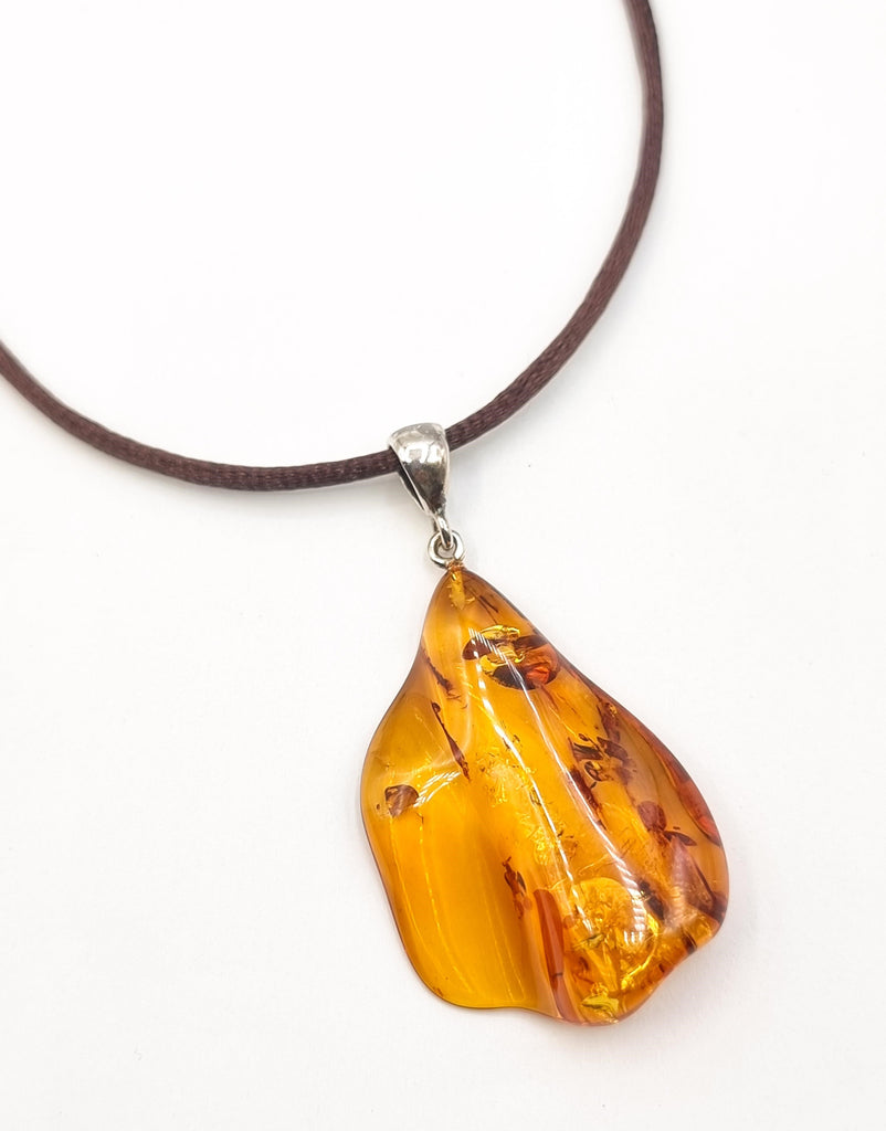 This exquisite freeform pendant is crafted from natural Baltic Amber, accentuated with a Sterling Silver bail. Its beautiful and unusual design reveals the inclusions and the natural form of the cognac Amber perfectly. Truly unique. Origin Poland